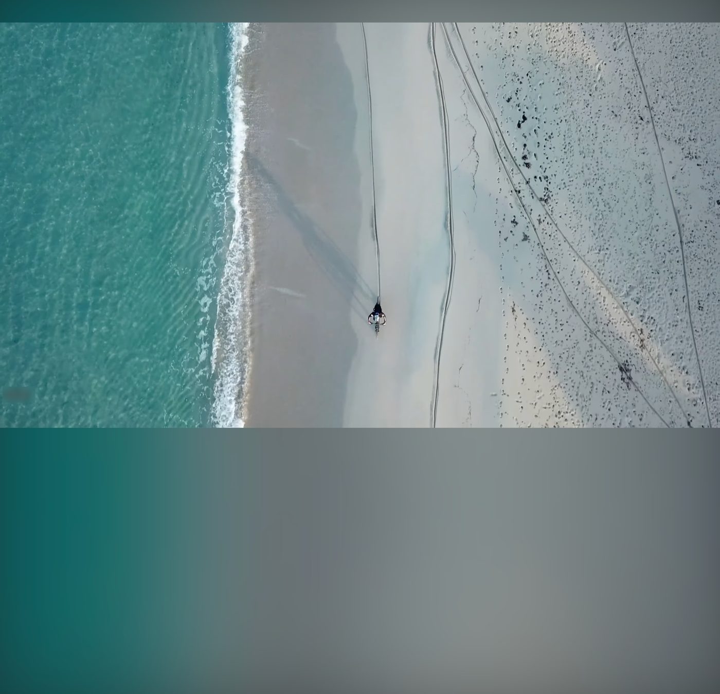 海辺の空撮映像で、画面が青緑色に染まっている